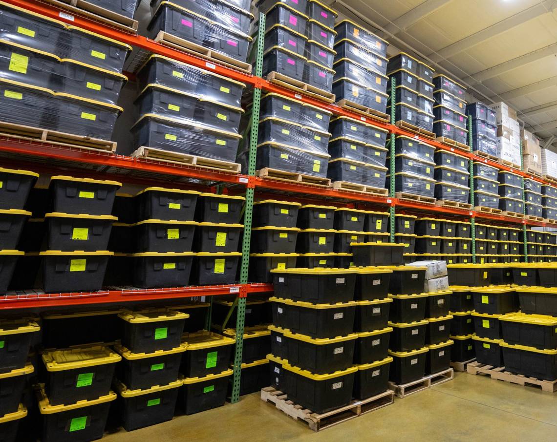 Warehouse racks holding labeled touring and merchandise totes